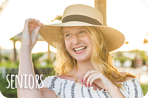 a white girl with blonde hair, wearing a tan hat, looking off to the left and smiling. Text says seniors.