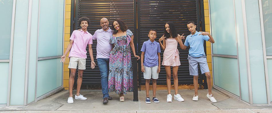 a black family in an urban setting - a teen b oy, dad, mom, tween boy, teen girl and another tween boy