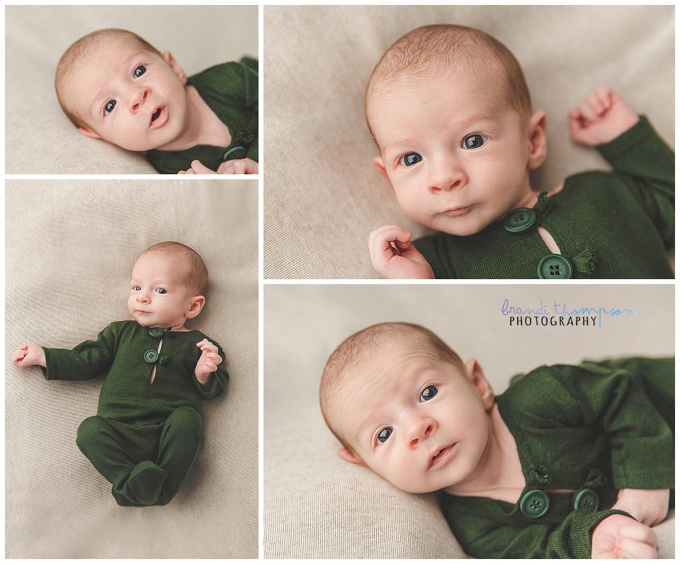 awake newborn b oy in green outfit on tan background