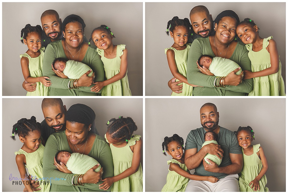 Black family dressed in shades of green with mom, dad, two young daughters and baby boy