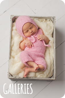Newborn baby girl sleeping in pink outfit in box